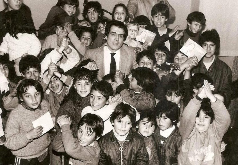 Miguel Abella, primer intendente de Río Cuarto durante la recuperación democrática, junto a un grupo de niños.